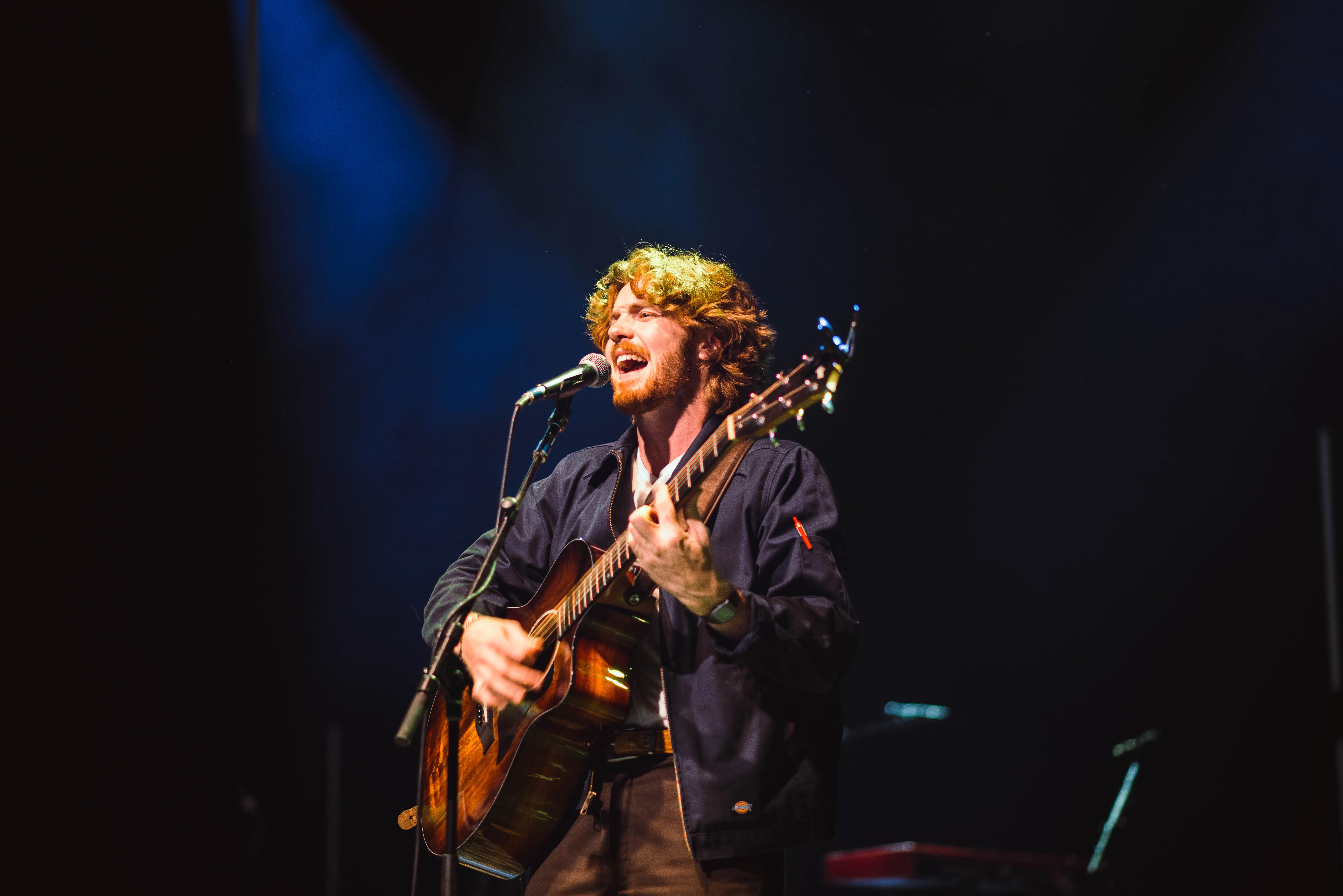 Live music performance photography by Thomas McClure of a singer on stage with dramatic high-contrast lighting
