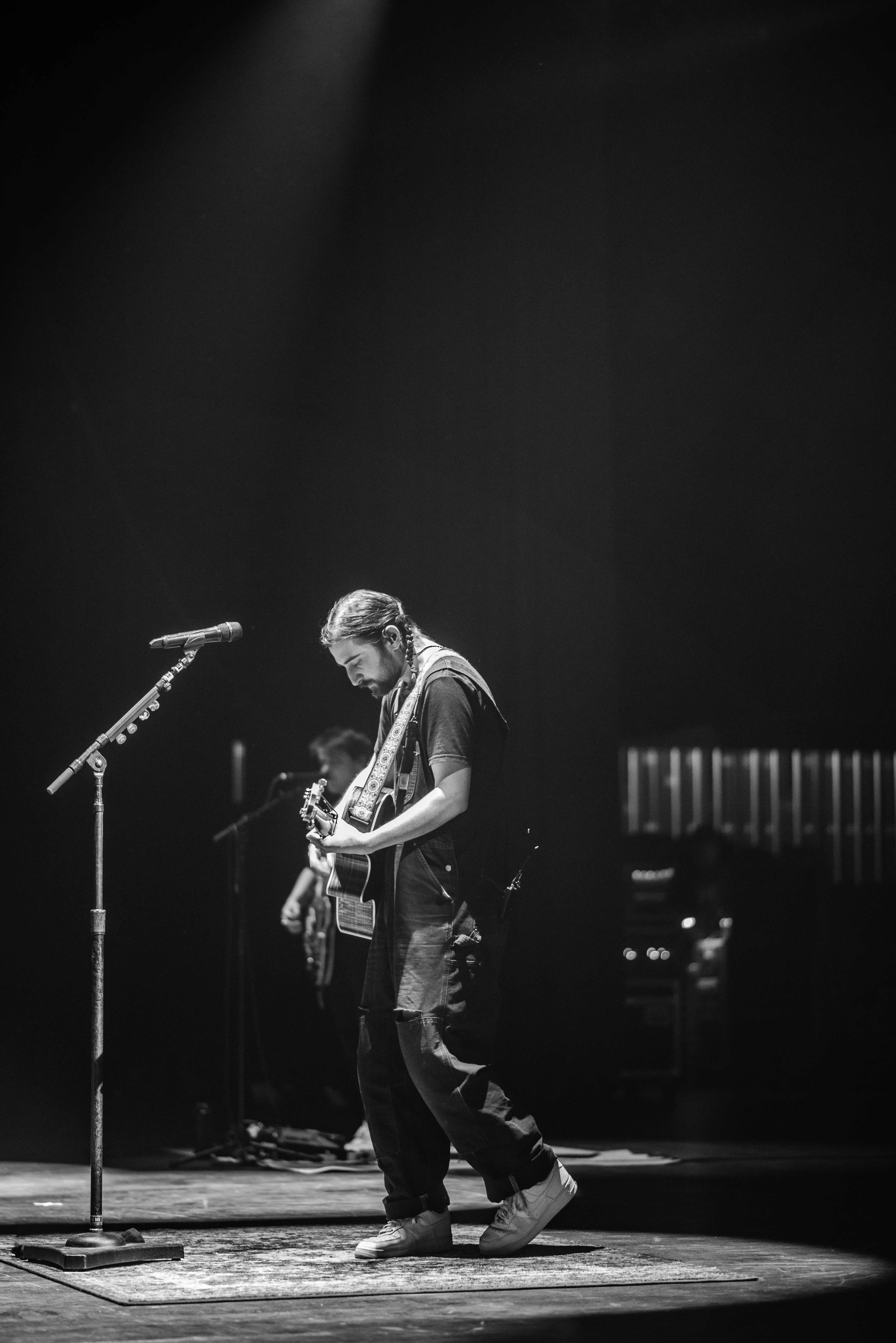 Moody musician portrait photography by Thomas McClure featuring acoustic guitar player under stage lights in West Lafayette