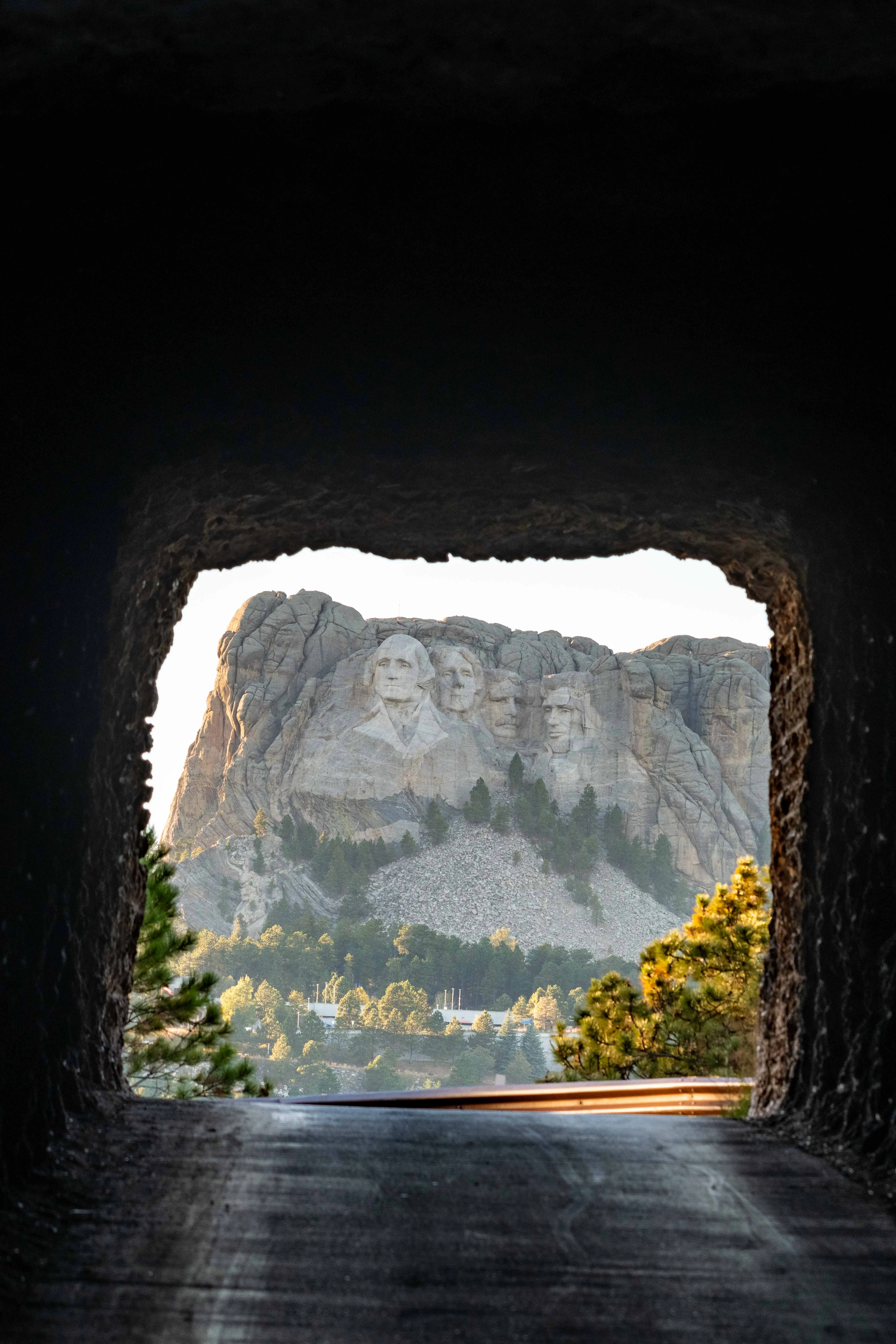 Fine art architecture photography by Thomas McClure of Mount Rushmore National Memorial carved into granite rock face in Keystone South Dakota, shot through a tunnel as a frame.