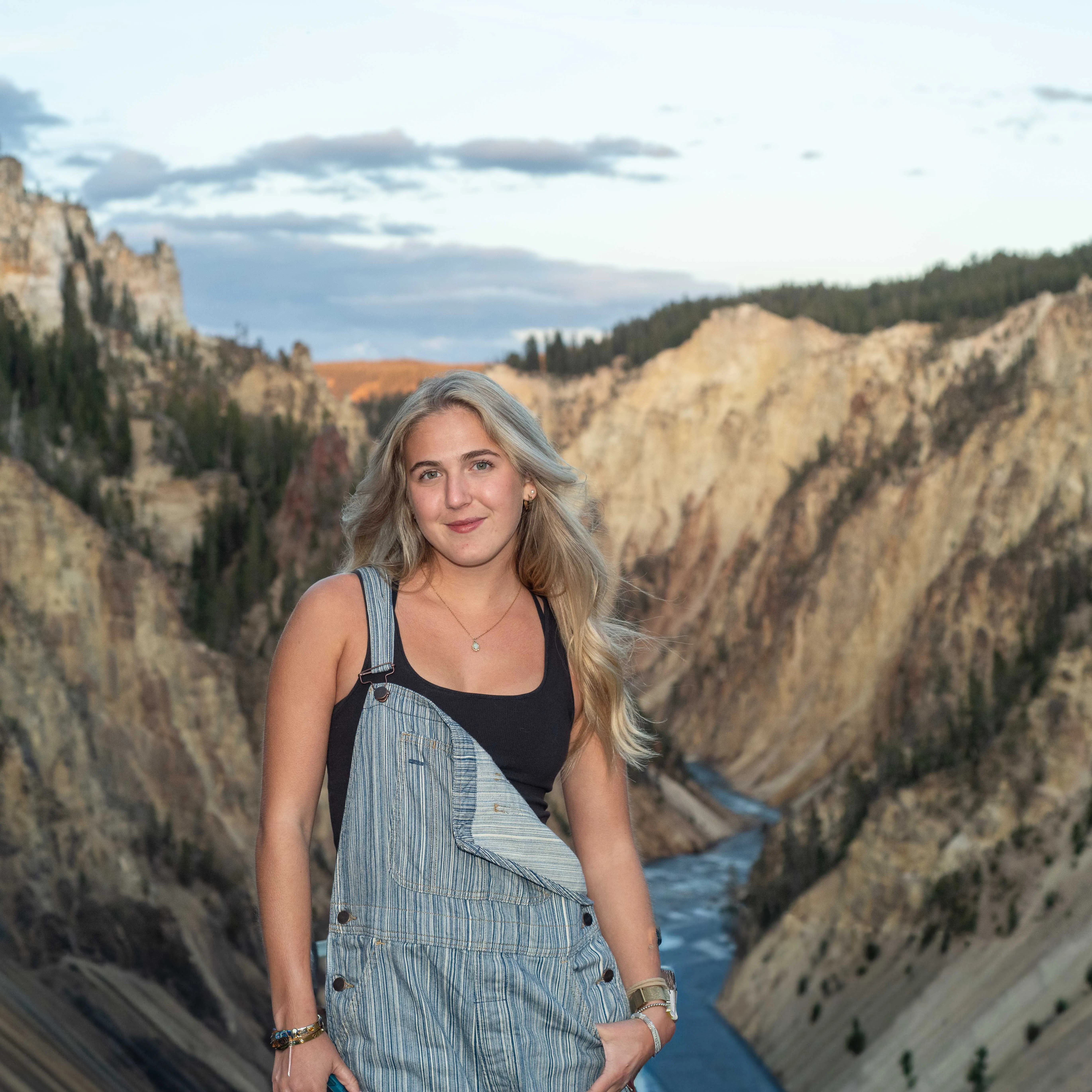 Environmental portrait photography by Thomas McClure of a woman standing against the vast landscape of Yellowstone National Park